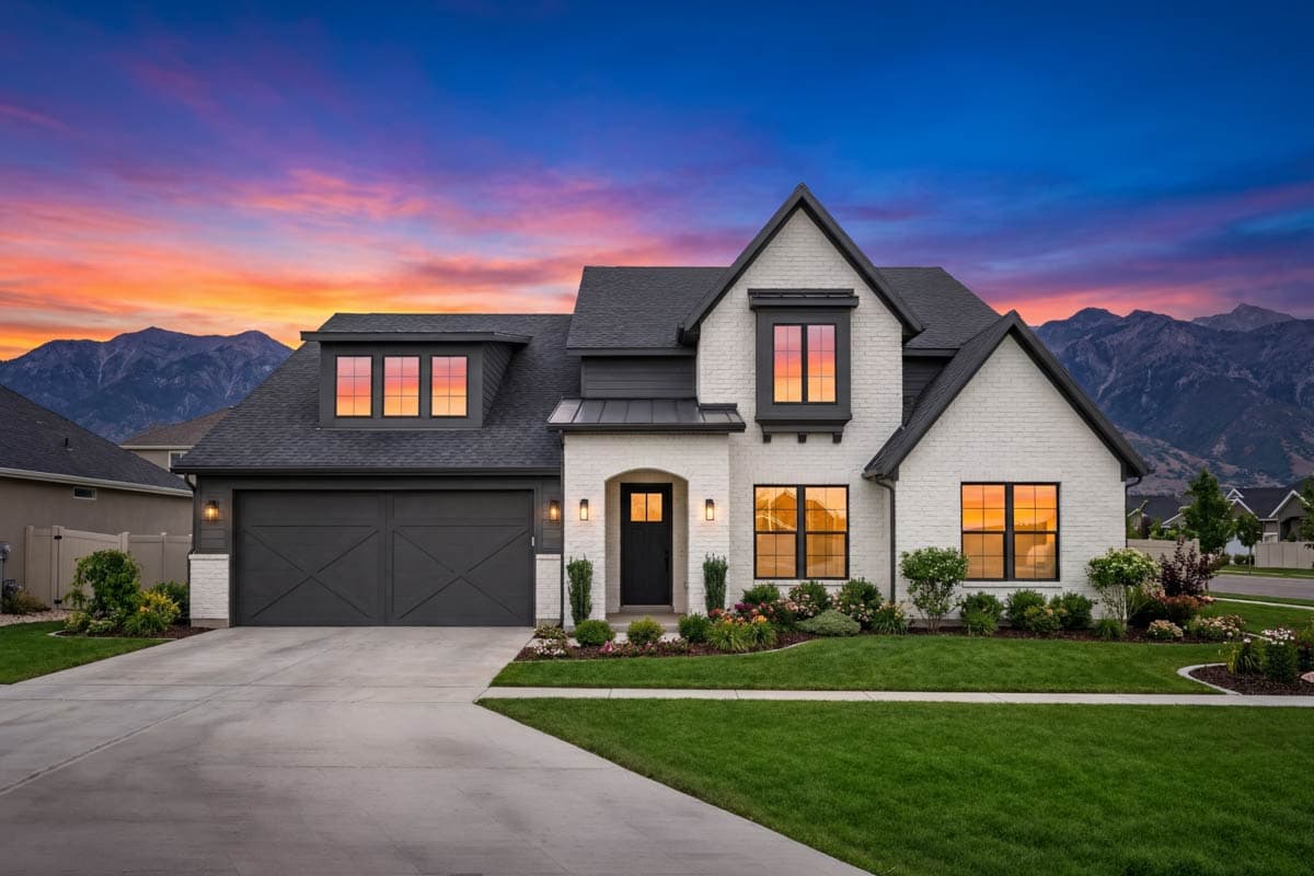 House plan exterior: Two-story modern farmhouse with white brick, dark gables, dormer windows, and a dual garage door.