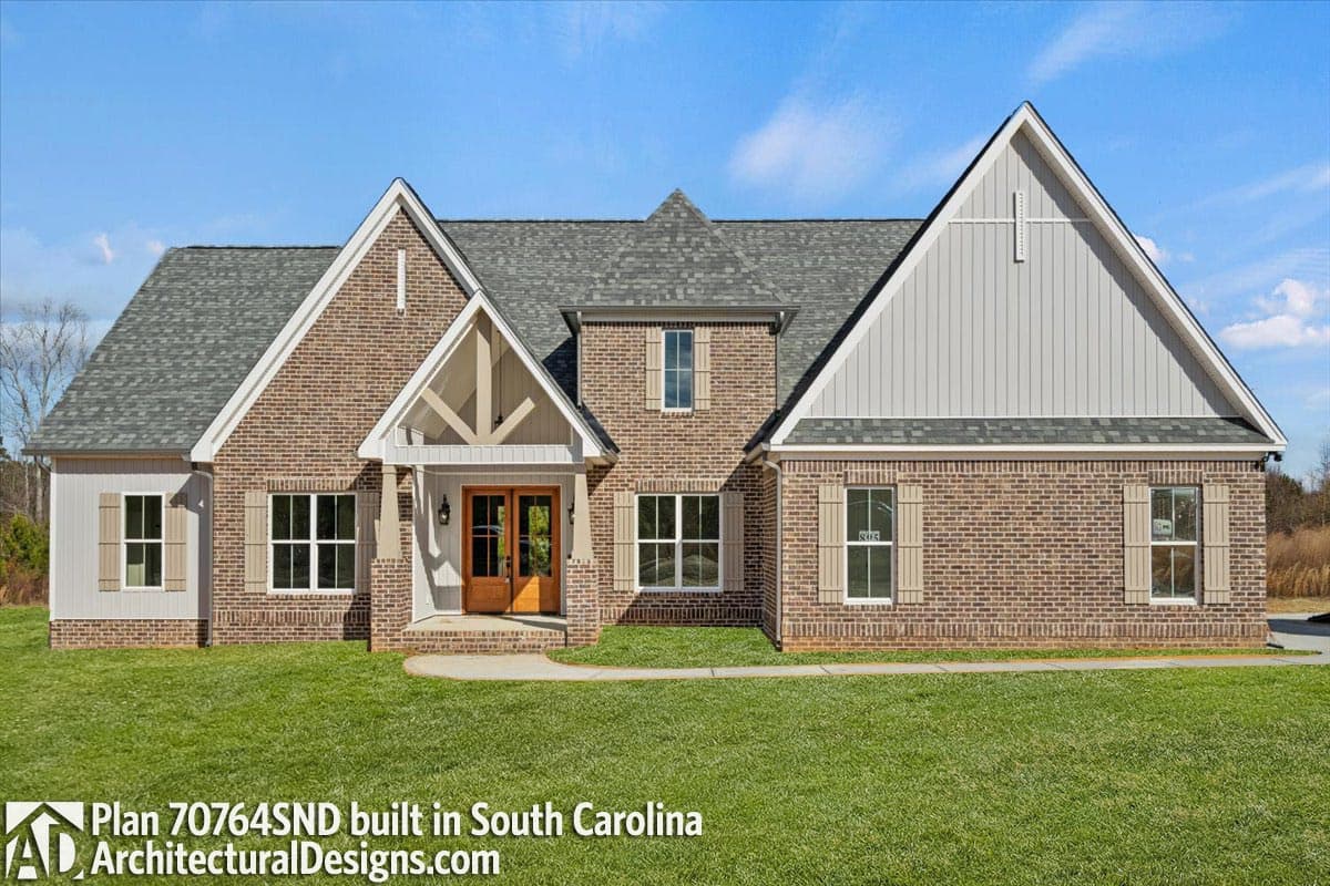 House plan exterior with brick facade, gables, dormers, double-door entry, and sloped rooflines.