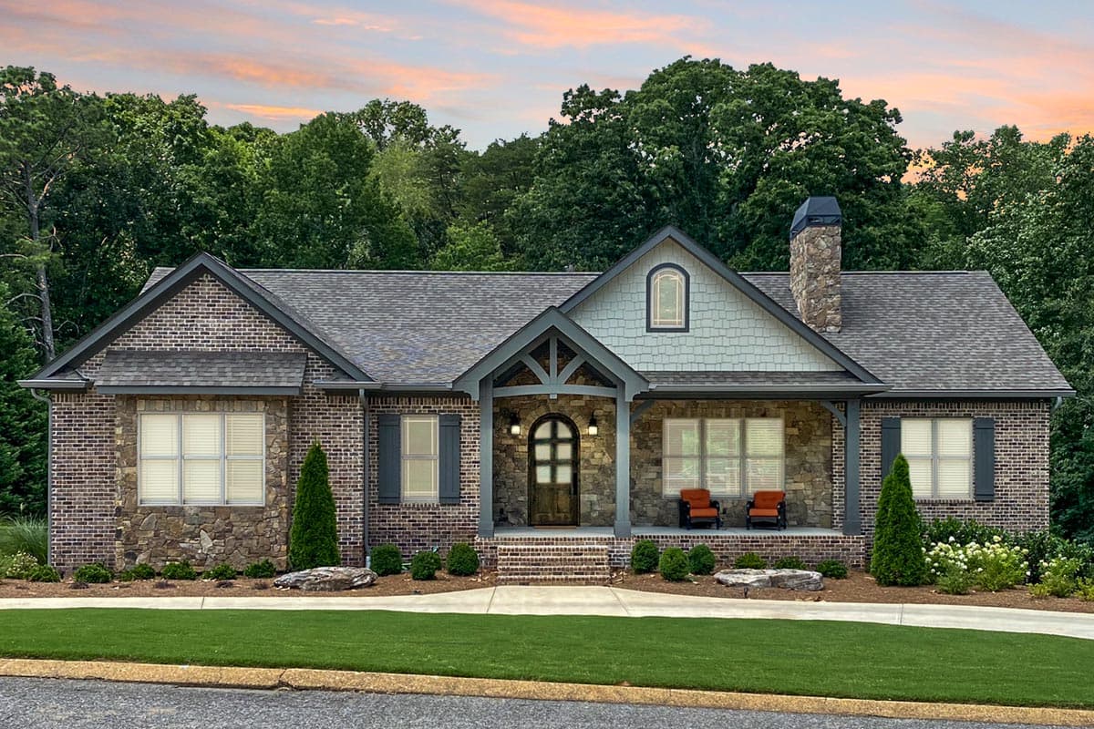House plan exterior: One-story brick home with stone accents, prominent gabled entrance, stone chimney, and covered porch.