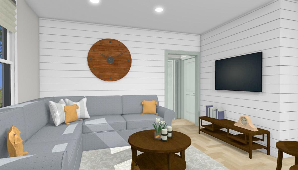 Living room with gray sectional sofa, shiplap walls, wall-mounted TV, and wood coffee table.