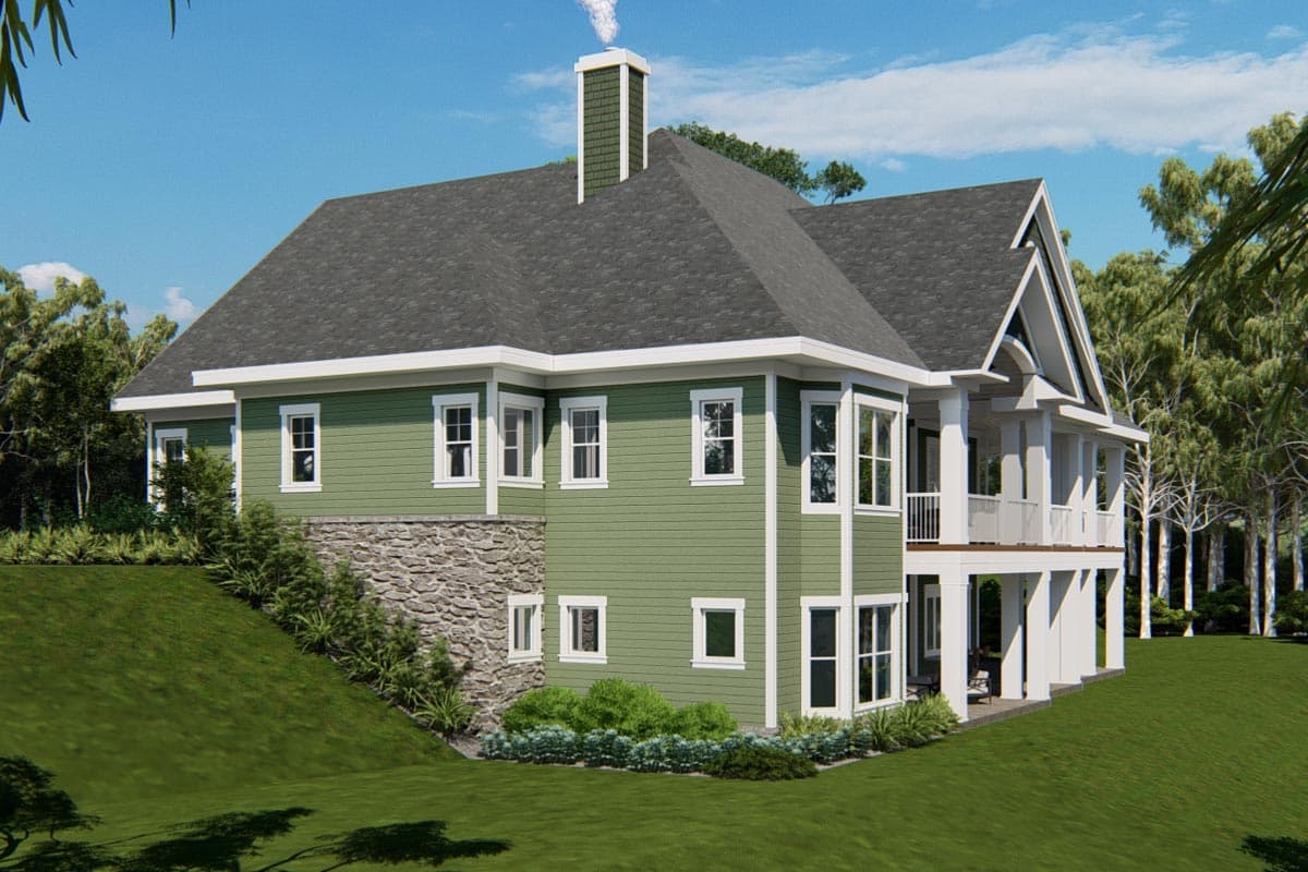 House plan exterior: green siding, stone base, gabled roof, multi-story covered porch, and prominent chimney.