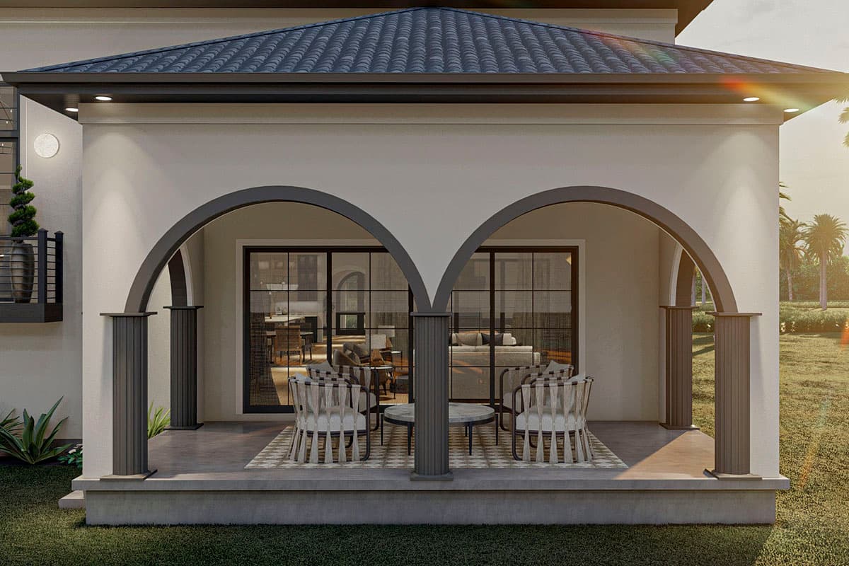 Exterior view of house plan featuring arched loggia, dark tile roof, and tall fluted columns.  Interior visible through French doors.