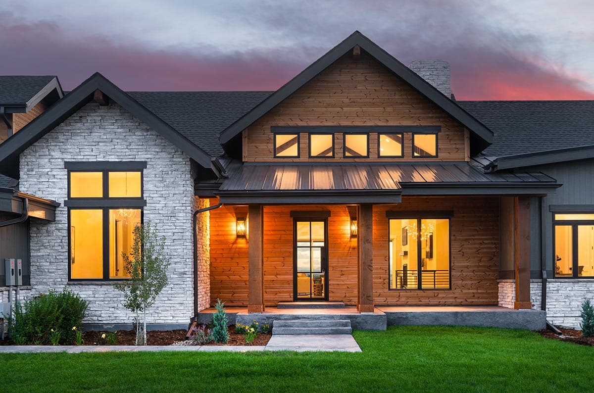 Modern house plan exterior with stone and wood siding, covered porch, and multiple gables.