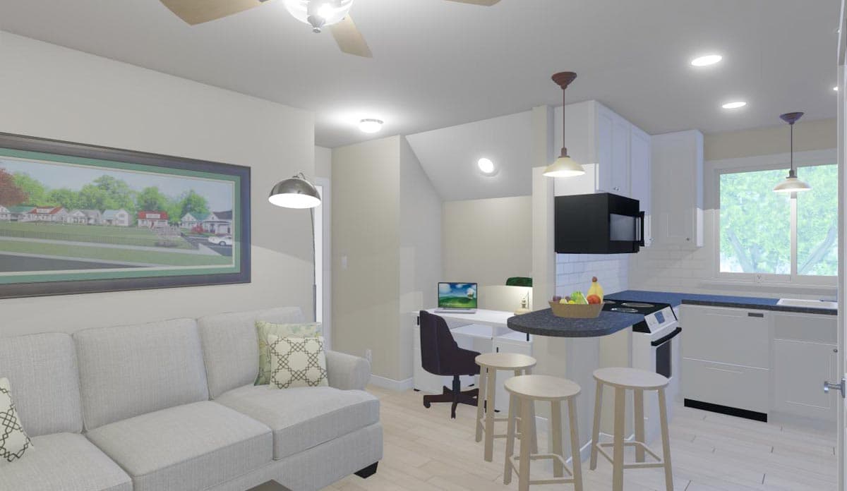 Open concept living area with sofa, kitchen island with stools, desk, and cabinetry.