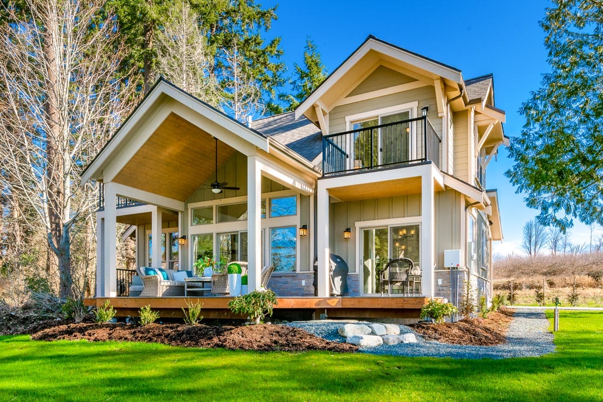 House plan exterior: Two-story modern farmhouse with covered porch, gables, and second-story balcony.