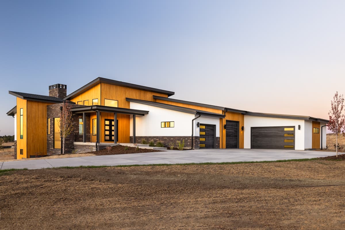 Modern house plan exterior with wood siding, stone accents, covered entry, and three-car garage with contemporary doors.
