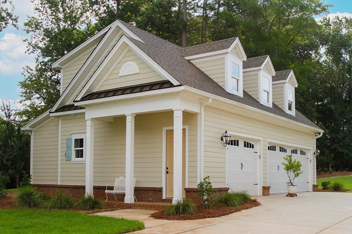 House plan exterior with gabled dormers, a covered porch with columns, and a three-car garage.
