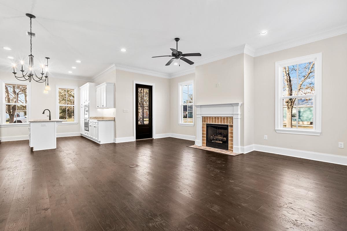 Open concept living area with kitchen island, fireplace, and large windows.