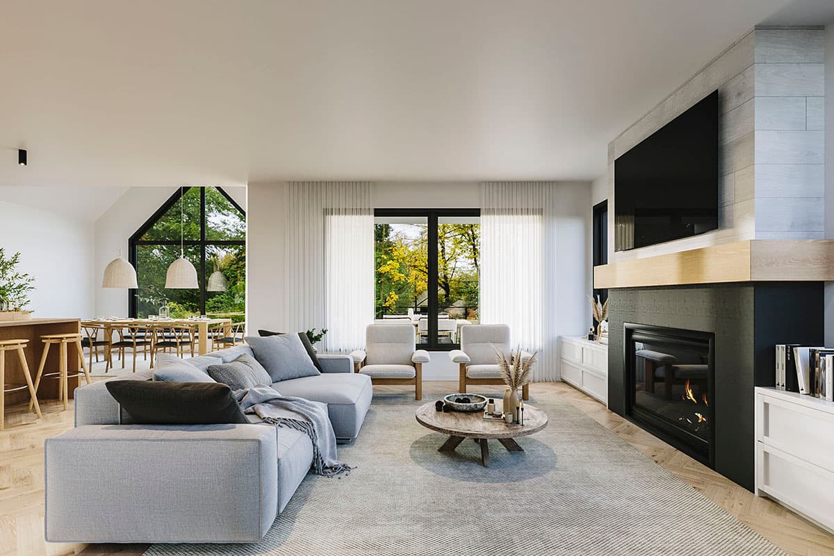 Living room with fireplace, sectional sofa, and dining area with large gable window.