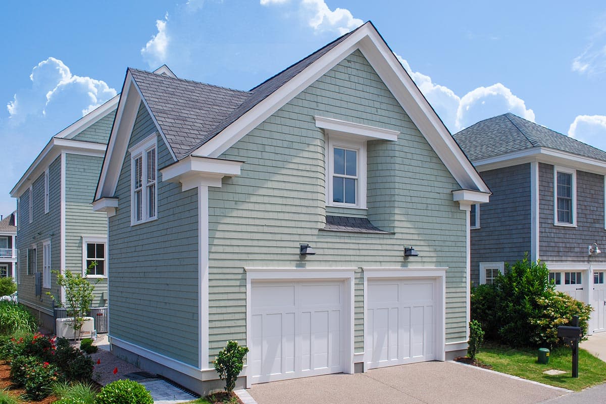 House plan exterior featuring a two-car garage with gabled roof, clapboard siding, and dormer window.