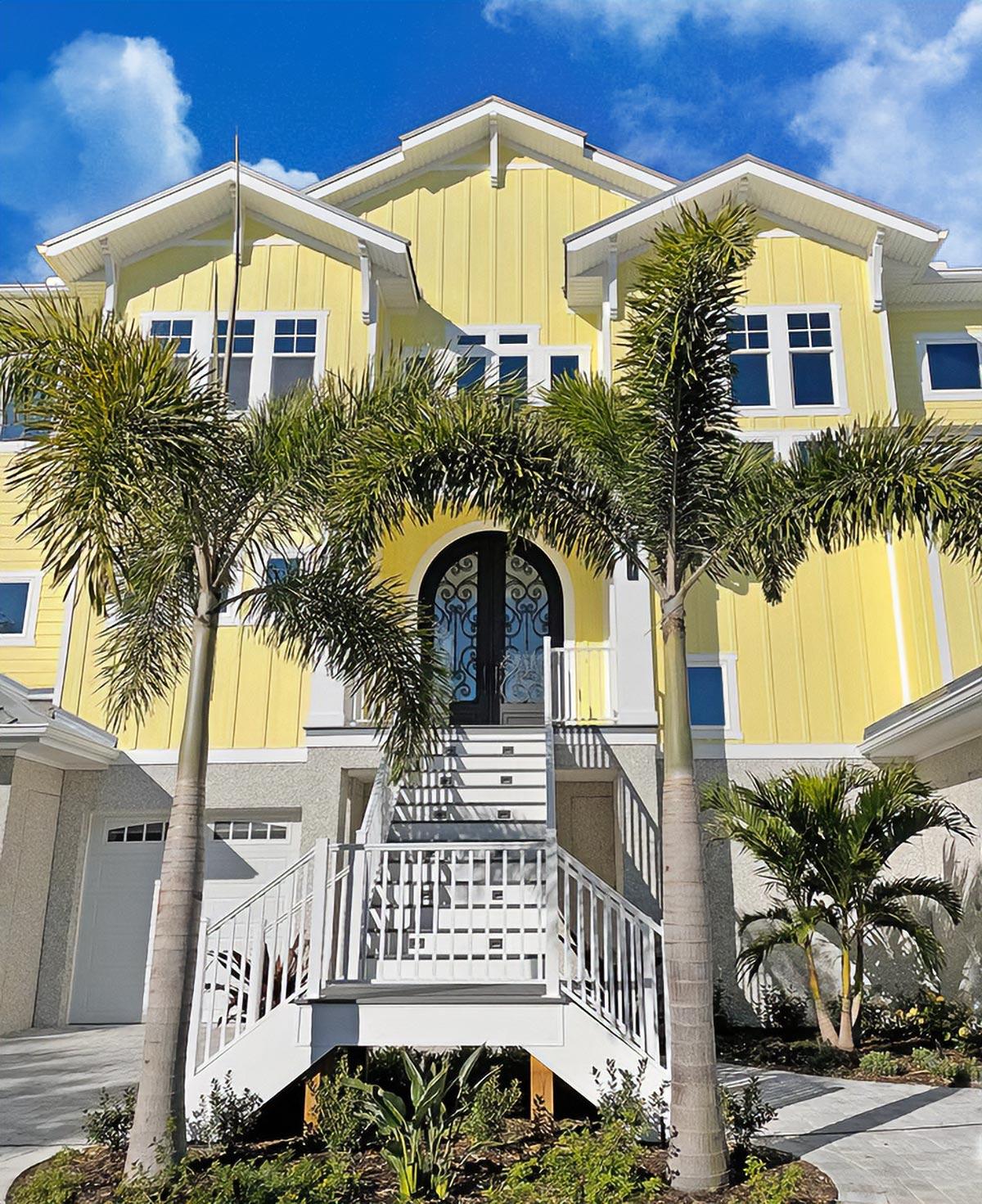 House plan exterior: Contemporary style with multiple gables, prominent staircase to arched double doors, and garage.