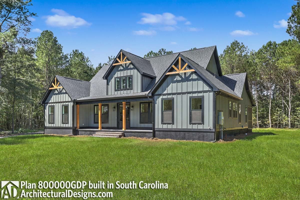 Modern Farmhouse style house plan exterior with covered front porch, gables with decorative wood trusses, and board and batten siding.