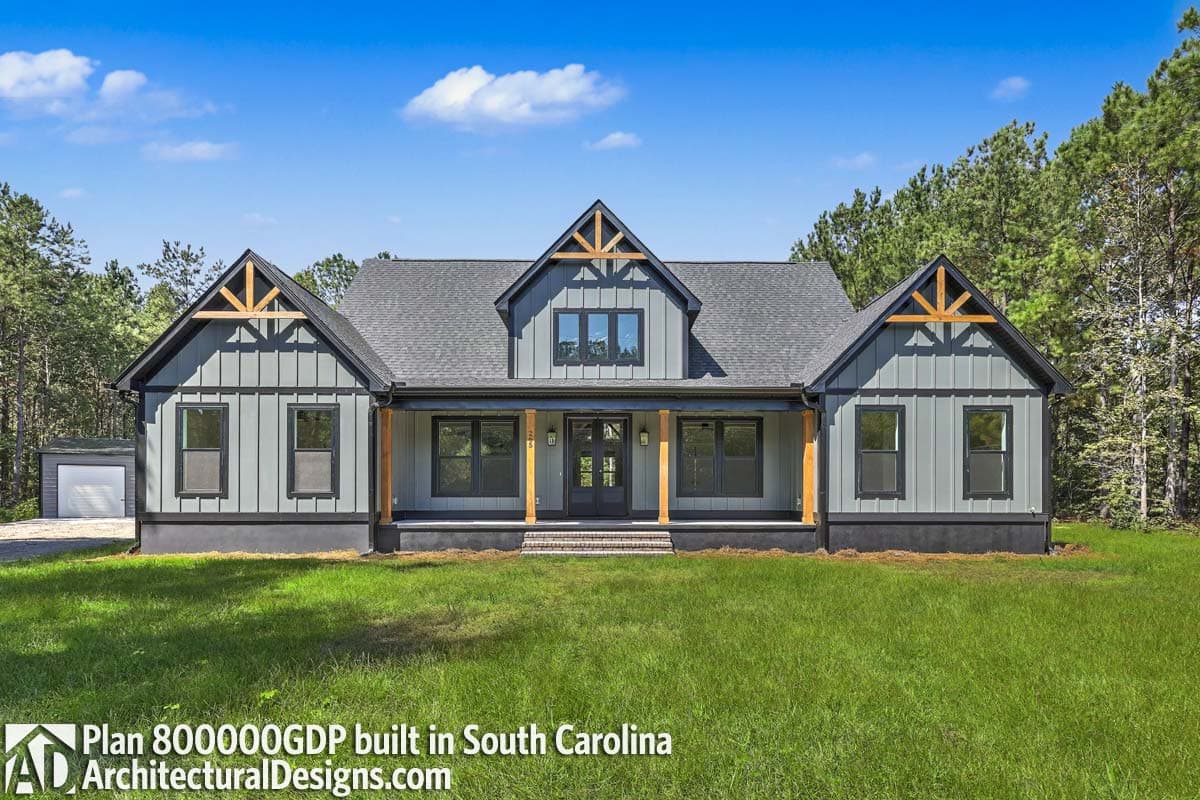Modern Farmhouse house plan exterior with board and batten siding, large front porch supported by timber posts, and prominent gables with exposed rafters.