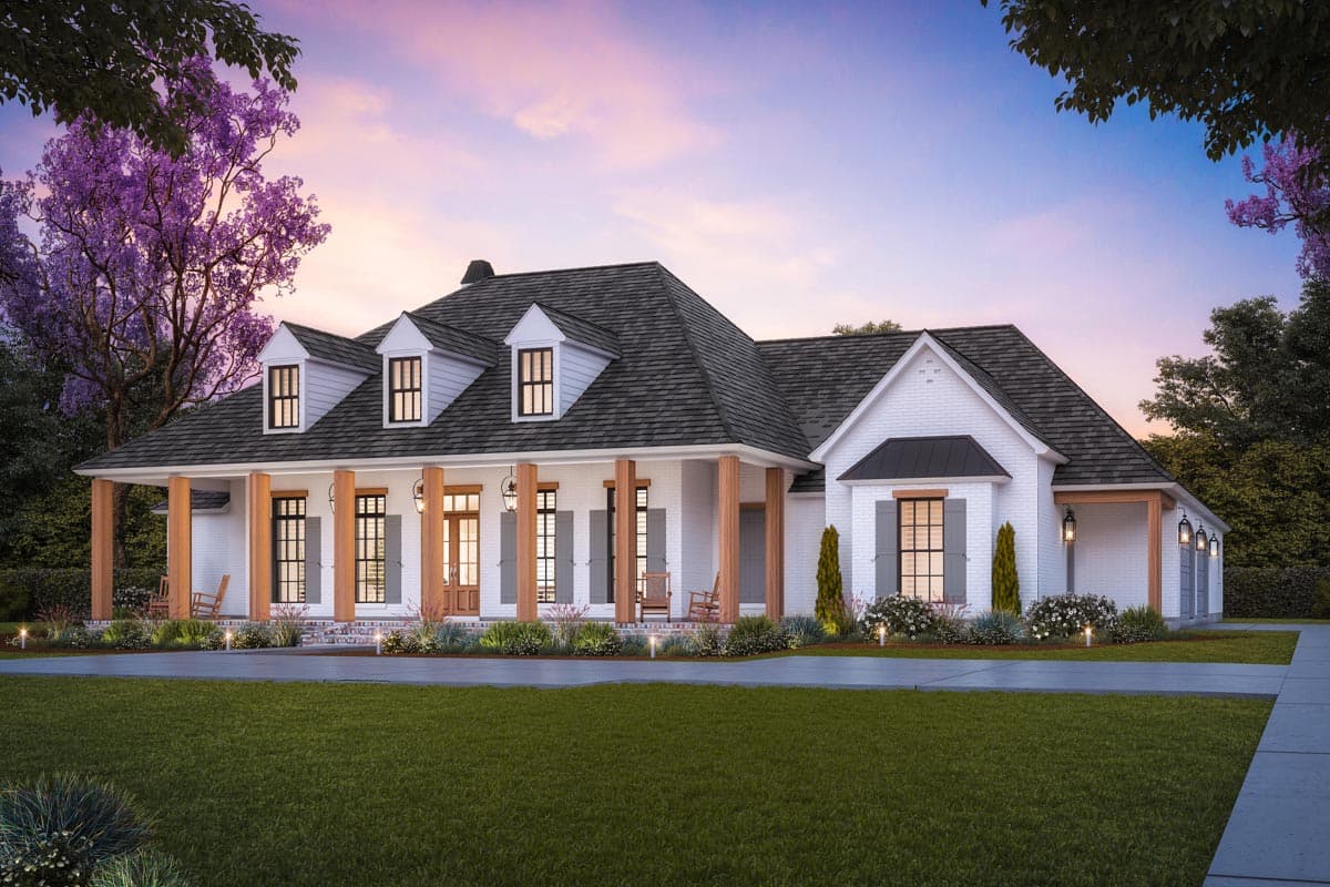 House plan exterior: Single-story white brick home with a deep wraparound porch, multiple gables, and dormer windows.