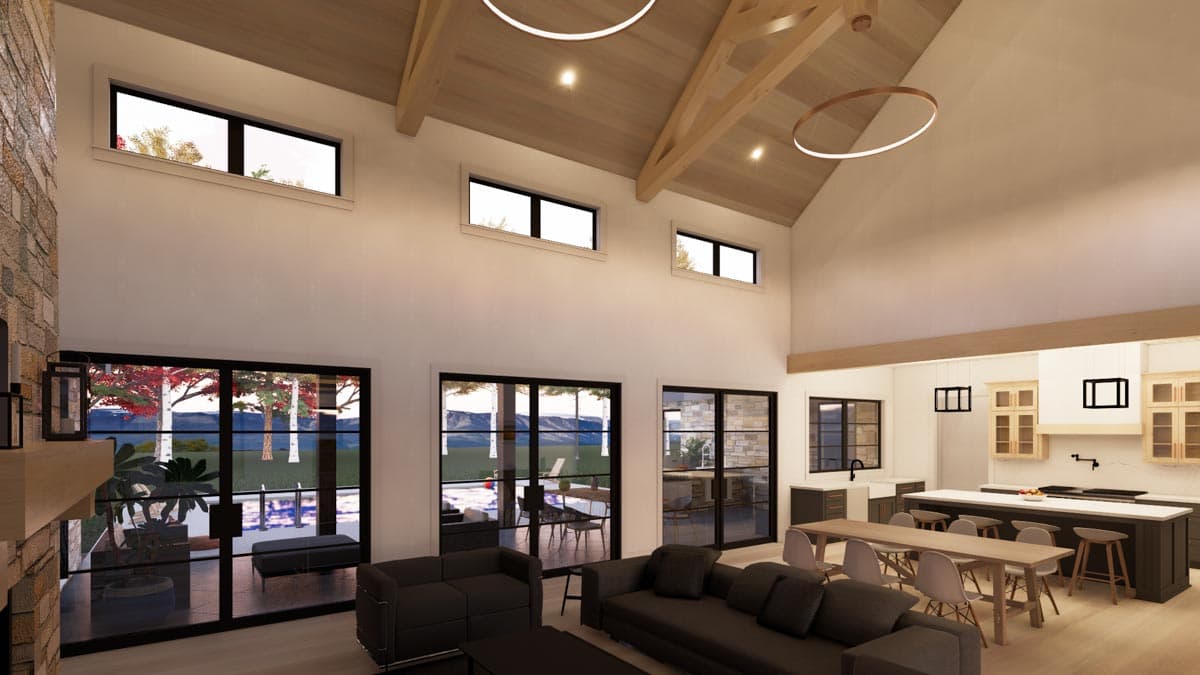 Spacious modern home interior with a vaulted ceiling. Large windows offer views of the outdoors, while contemporary furniture sits in the open-plan living area.