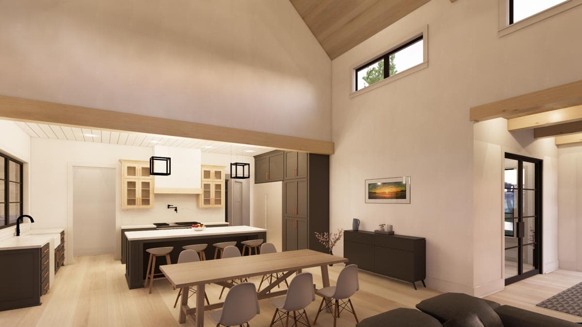 A spacious, modern kitchen with a large island and a long dining table. High ceilings and large windows create an airy, well-lit space.