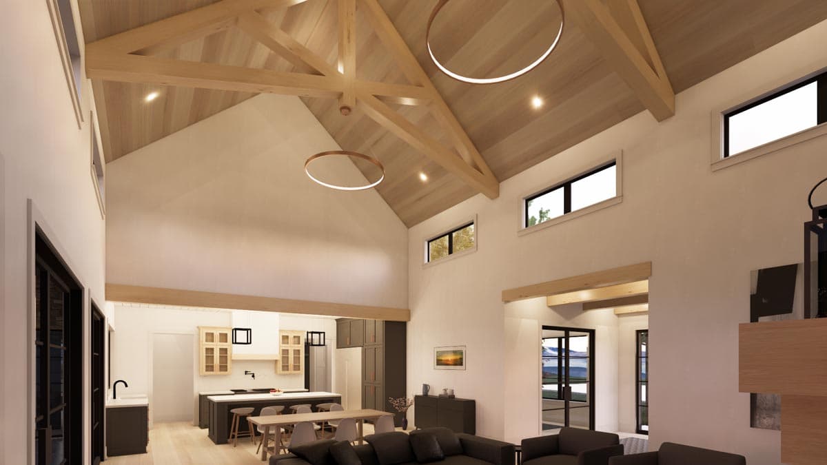 Modern, open-concept home interior with high ceilings. Features wood beams, ring lights, a kitchen with an island, and a seating area with a sofa.