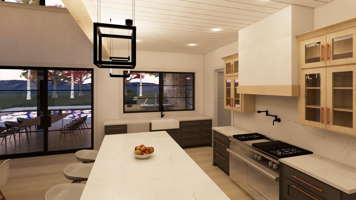 Modern kitchen with large island, granite countertops, dark gray cabinetry, stainless steel appliances, and a view of trees and mountains.