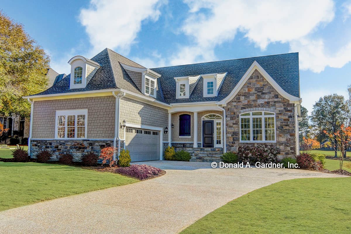 House plan exterior with stone and shingle siding, dormers, and gabled roof. Features a front-facing garage and covered entry porch.