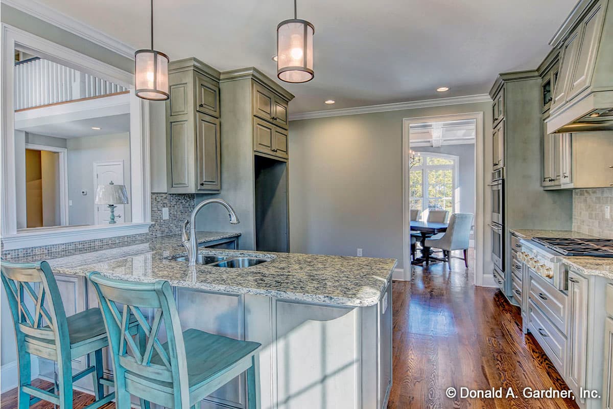 Kitchen with island, granite countertops, and stainless steel appliances, open to dining area.