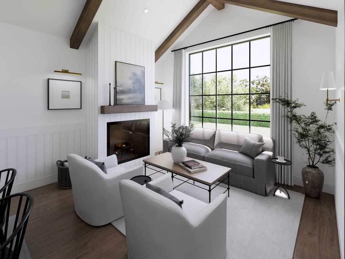 Cozy living room with a fireplace, a large window overlooking a lush green landscape, and modern gray sofa with white armchairs.