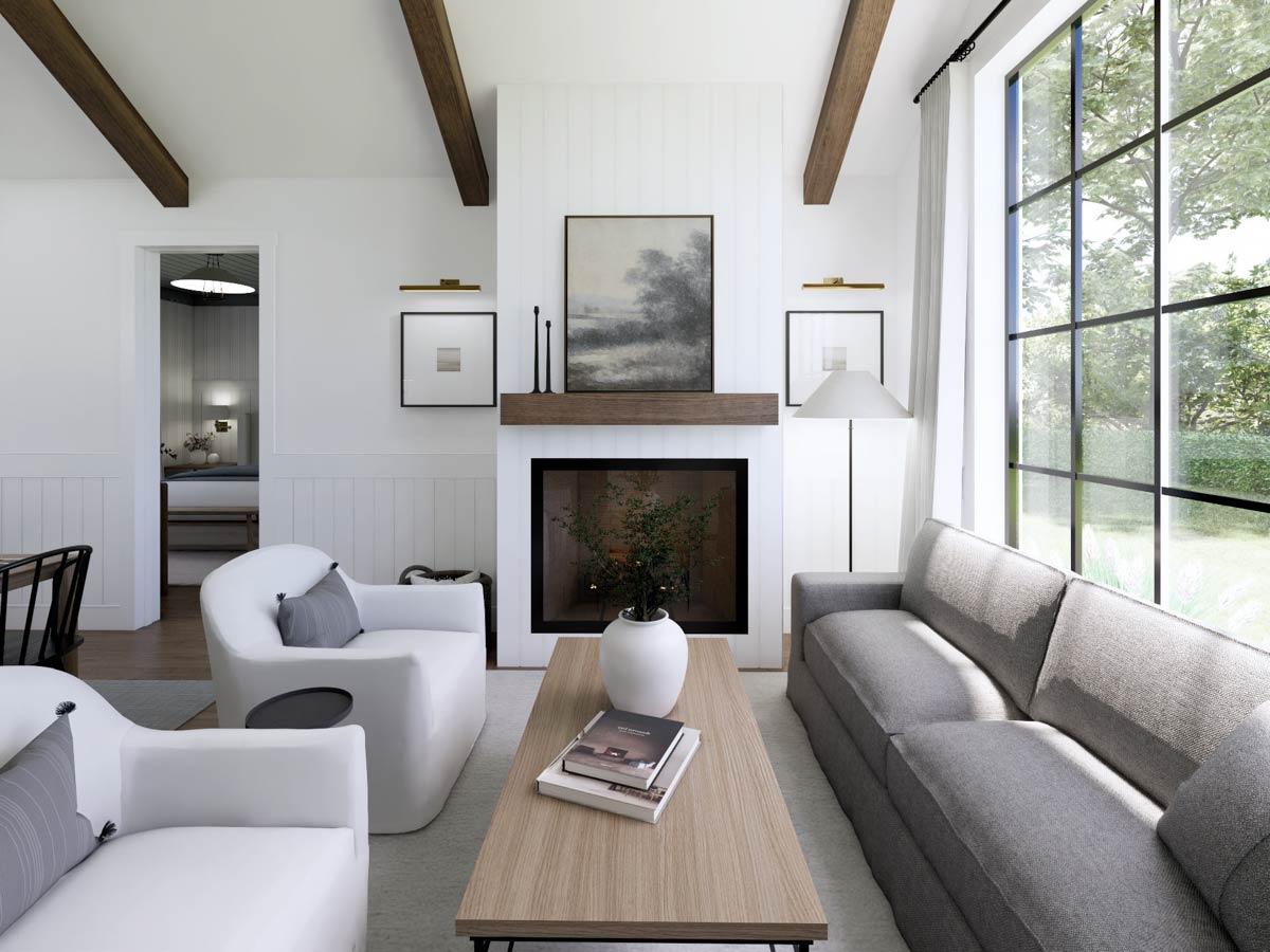 A modern living room with a fireplace, white walls, and a large window looking out onto a green landscape. Furnished with white and grey.