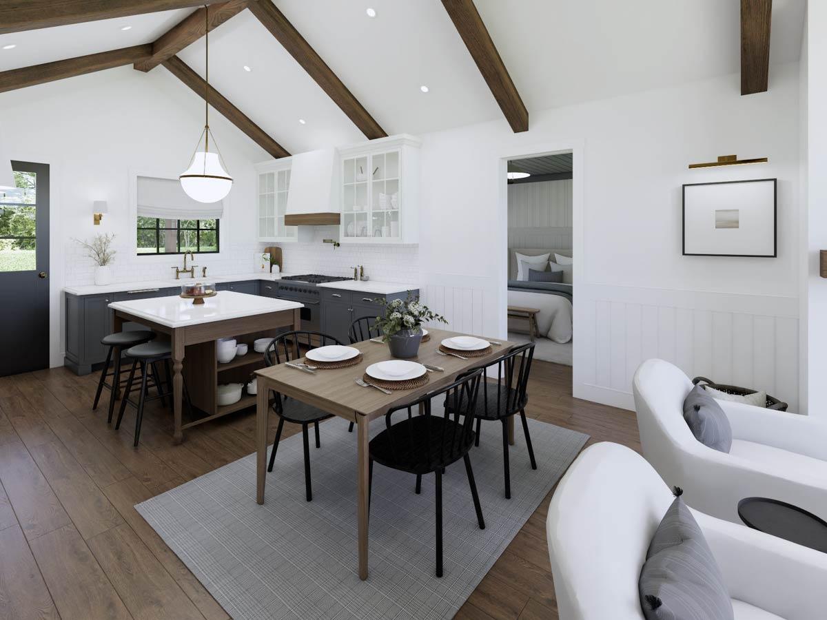 Spacious, bright kitchen and dining area featuring a table set for a meal, a kitchen island, and open access to a bedroom.
