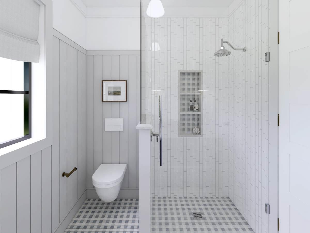 Modern bathroom with gray and white tile, a glass shower, and a wall-mounted toilet. Framed artwork hangs above the toilet in the serene space.