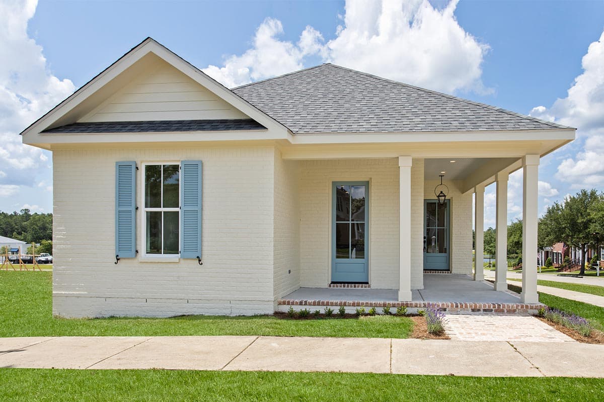 House plan exterior. One-story Cottage style with a front porch supported by columns. Features include gabled roof and brick facade.