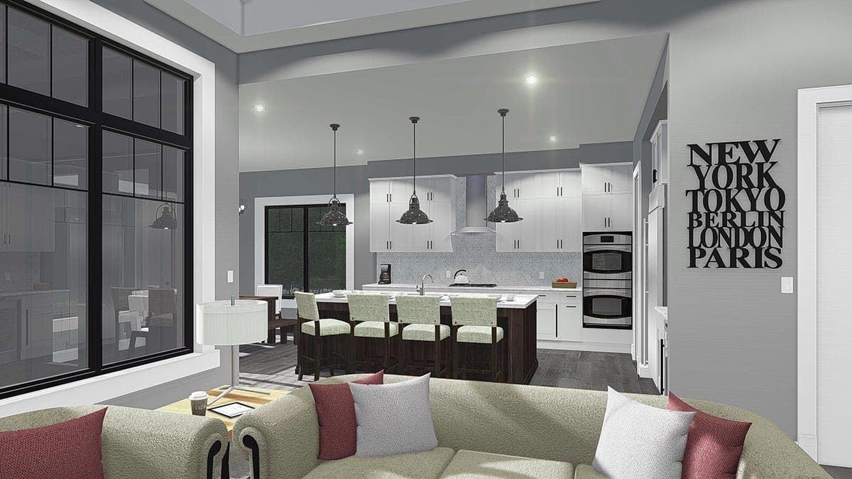 Open-plan living area with large window, kitchen island with bar stools, white cabinetry, and double ovens.