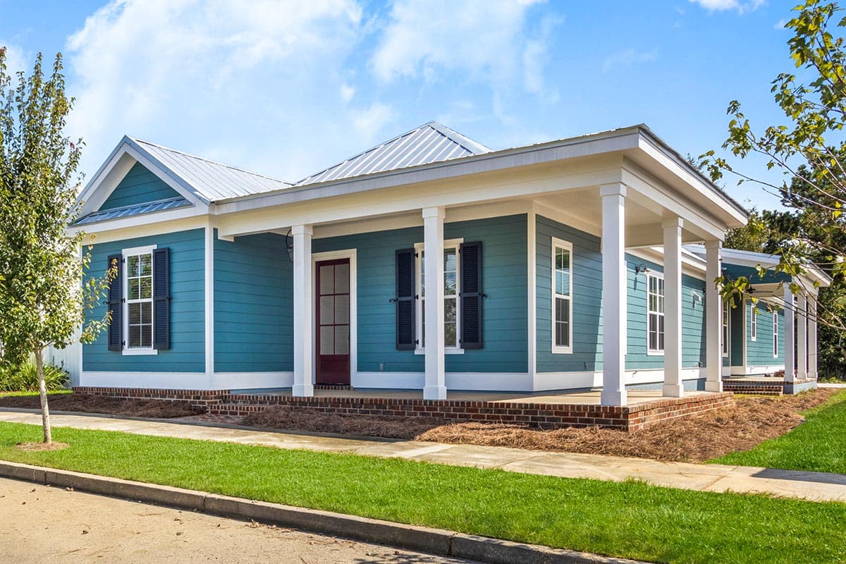 House plan exterior. Single-story Craftsman home with a front porch supported by columns. Features include gables and a metal roof.