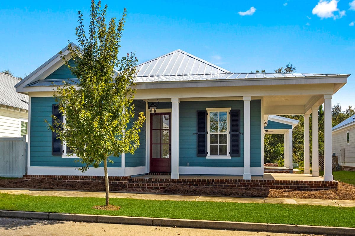 House plan exterior: one-story Modern Farmhouse with a metal gable roof, wraparound porch, and blue siding.