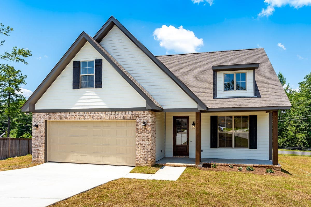 Modern Farmhouse house plan exterior with gable dormer, white siding, brick accents, and covered front porch with wood columns.