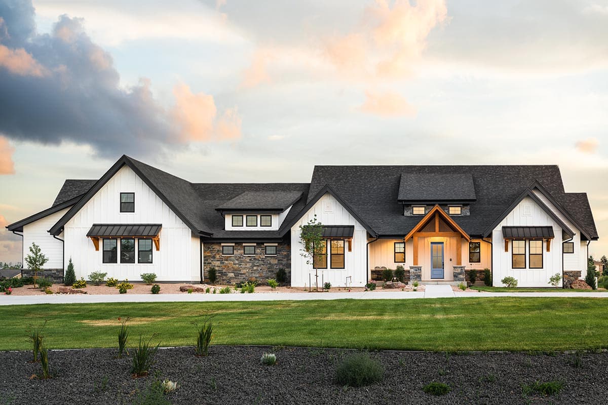 House plan exterior. Modern farmhouse style with gabled roof, board and batten siding, and shed-roofed dormers over windows.