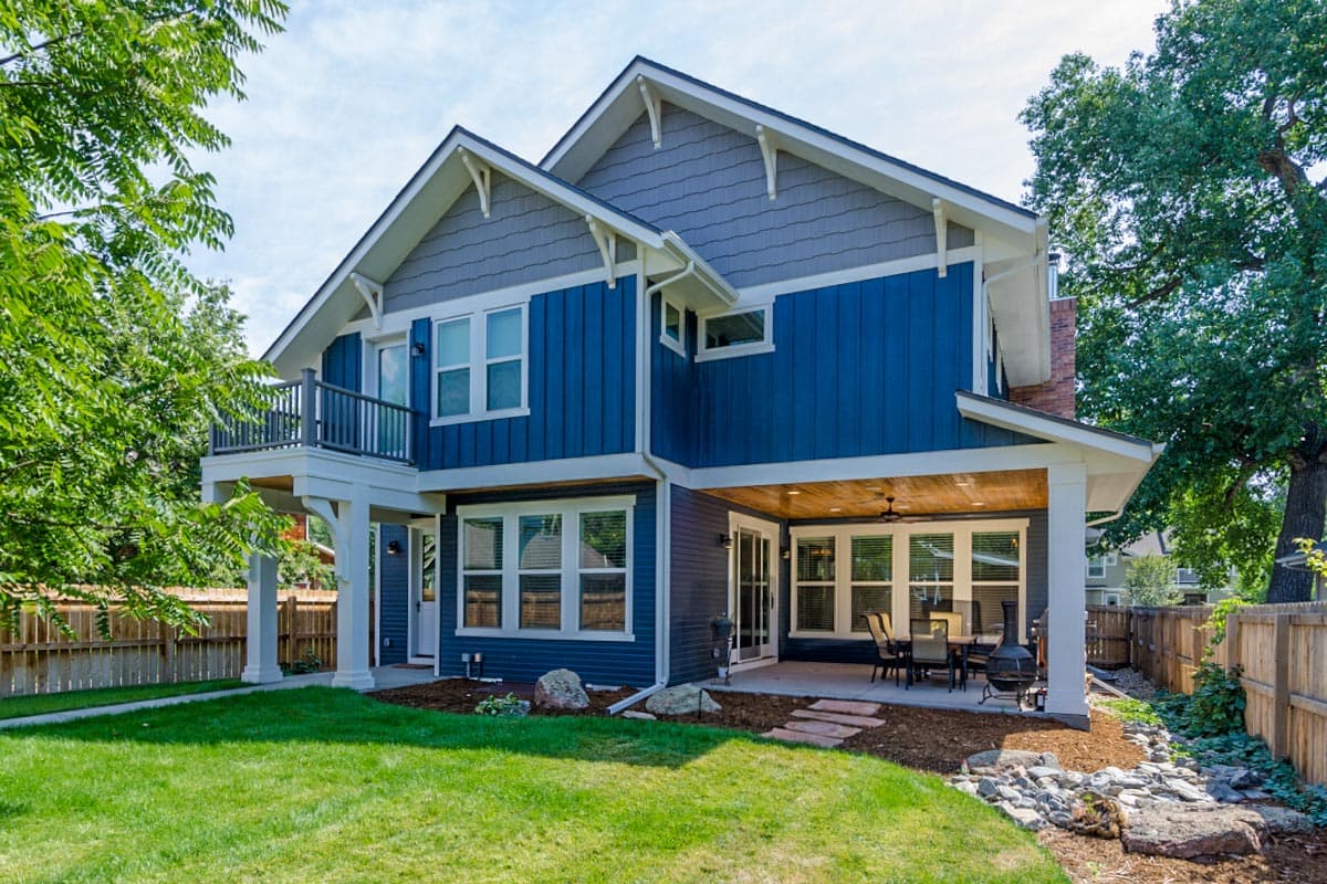 House plan exterior: two-story Modern Farmhouse with gables, dormers, a second-story balcony, and covered patio.