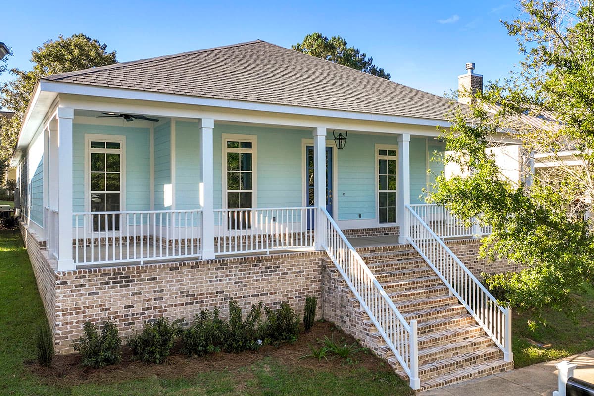 House plan exterior with Craftsman style, one story, brick foundation, front porch, and gabled roofline.
