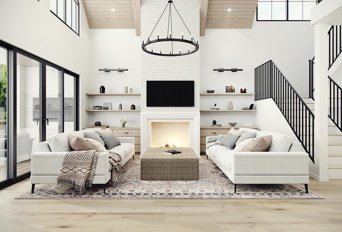 Great room with vaulted wood-beamed ceiling, fireplace, dual sofas, and an open staircase.