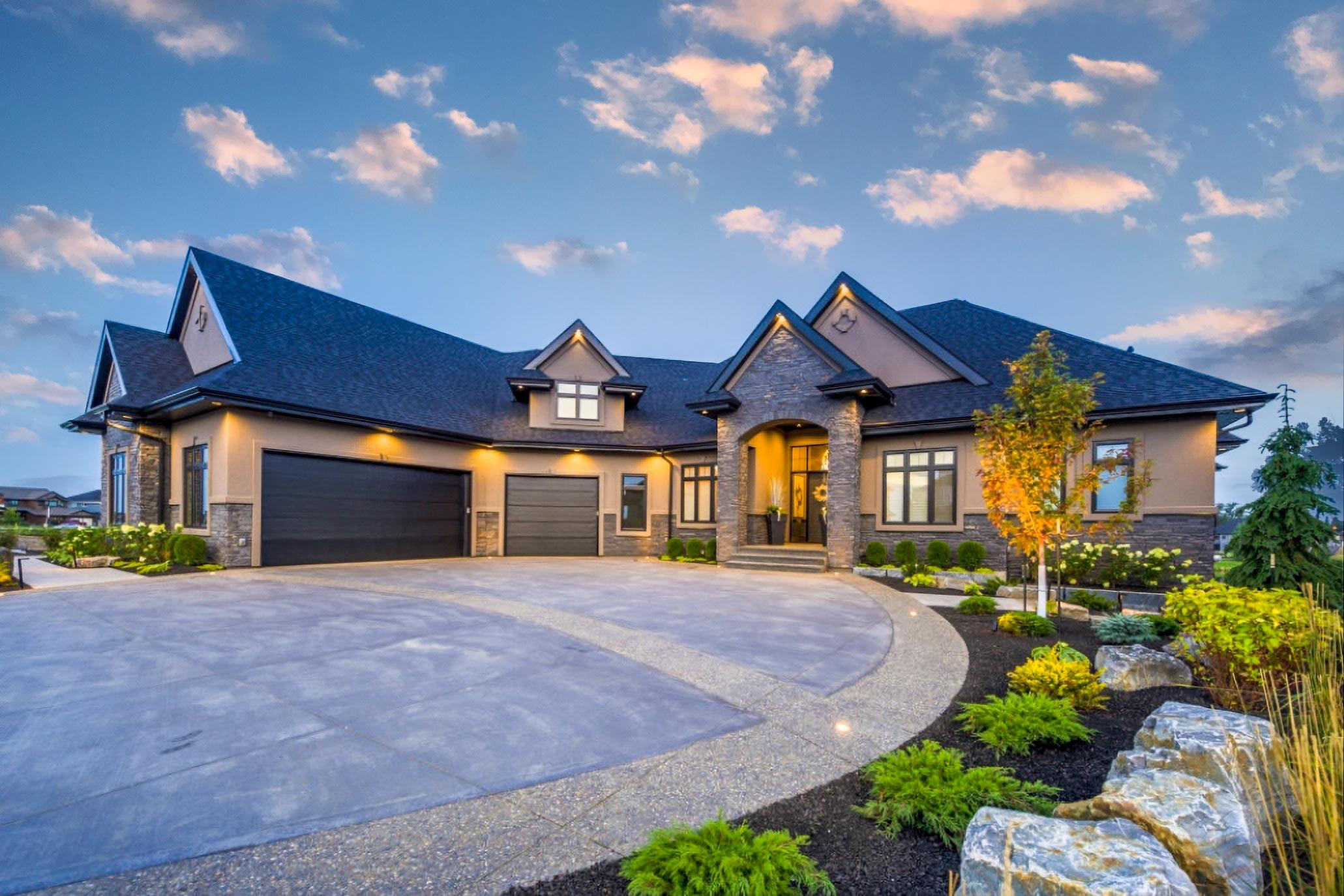 House plan exterior with two stories. Features include a porte-cochere, gable rooflines, and a three-car garage. Stone facade accents the entryway.