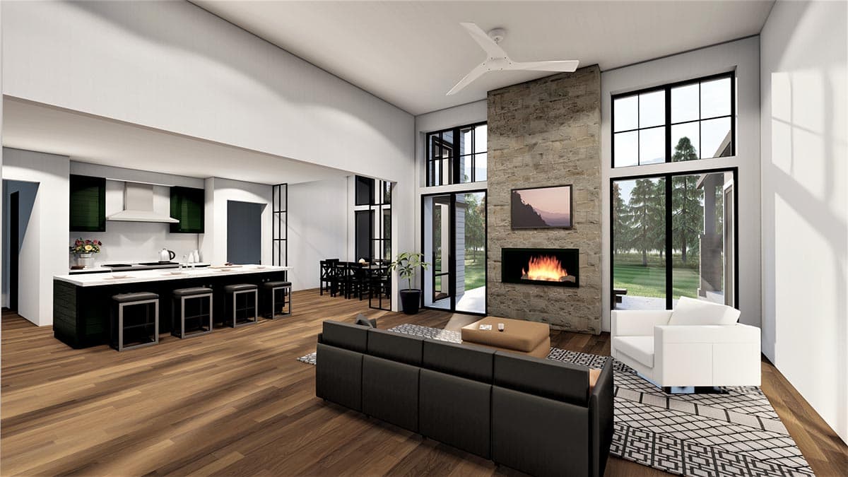 Open-concept living space with a large stone fireplace, vaulted ceiling, modern kitchen island, and dining area.