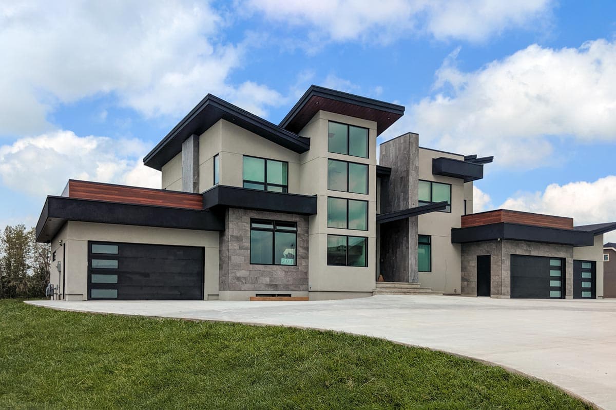 House plan exterior. Two-story modern home with flat roof, multiple large windows, and attached garage. Exterior features include stone accents.