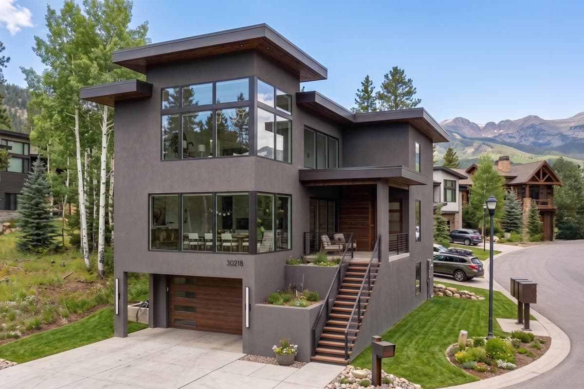Modern house plan exterior with stucco finish, large windows, flat roof, integrated garage, and elevated entry stairs.