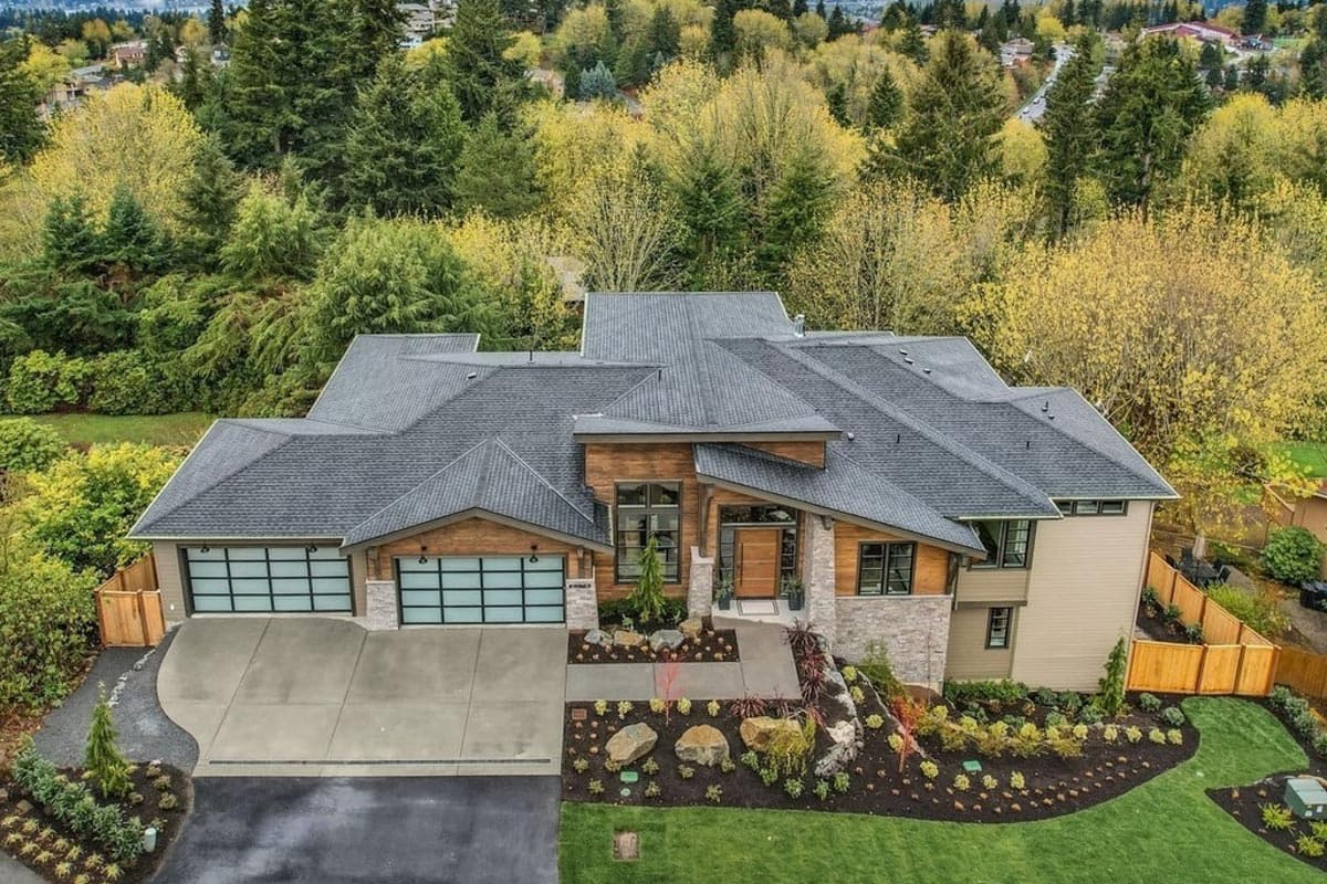 Modern house plan exterior with three-car garage, wood and stone accents, multiple gables, and pitched rooflines.