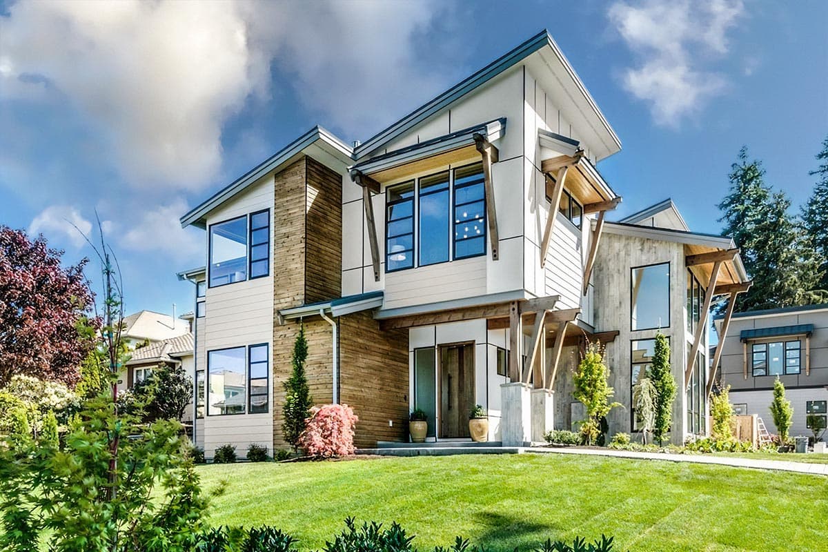 House plan exterior. Two-story Modern house with wood siding, multiple gabled rooflines, and a covered entry porch supported by timber beams.
