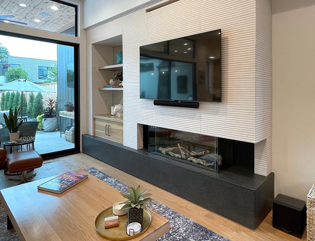 Living room with textured fireplace surround, gas fireplace, built-in shelving, and large sliding glass door to patio.