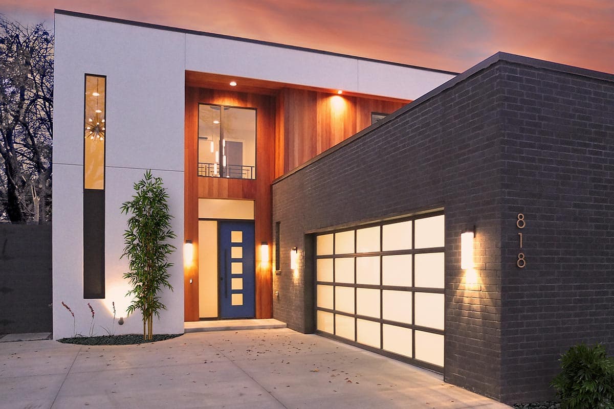 House plan exterior. Modern style with a two-story design. Features include a contrasting facade, wood accents, and a glass garage door.