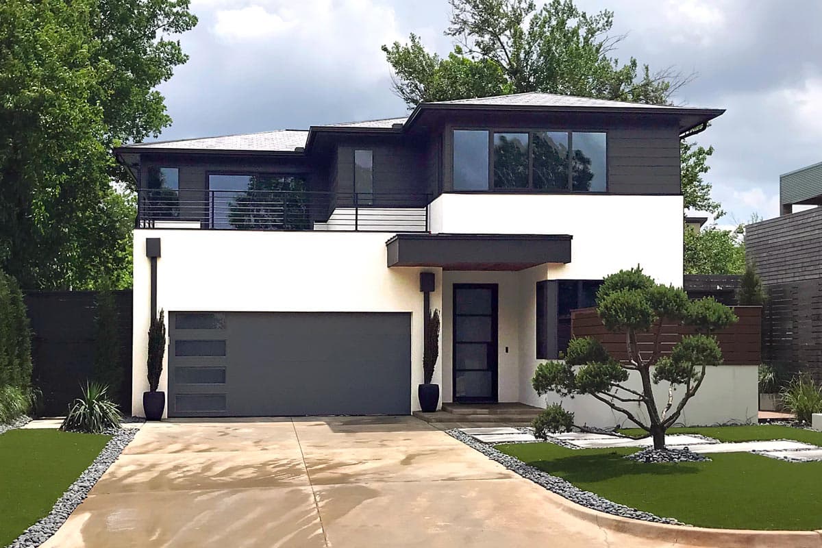 House plan exterior. Two-story Modern house with flat roof, horizontal siding, and a cantilevered entry. Features include a garage and a balcony.