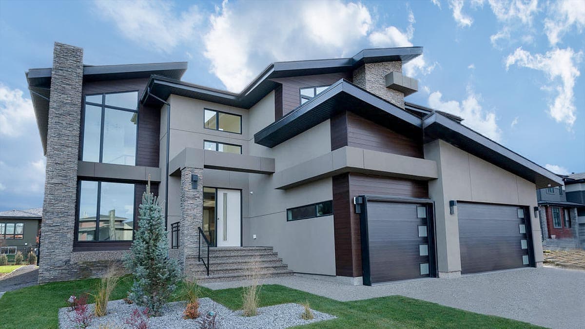 Modern house plan exterior with stone accents, cantilevered rooflines, multiple gables, and a three-car garage.