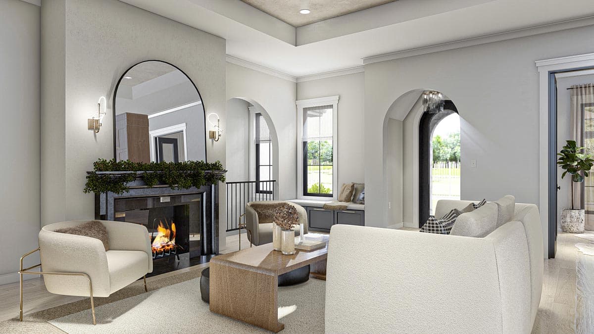 Living room with fireplace, arched entryway, window seat, and tray ceiling.