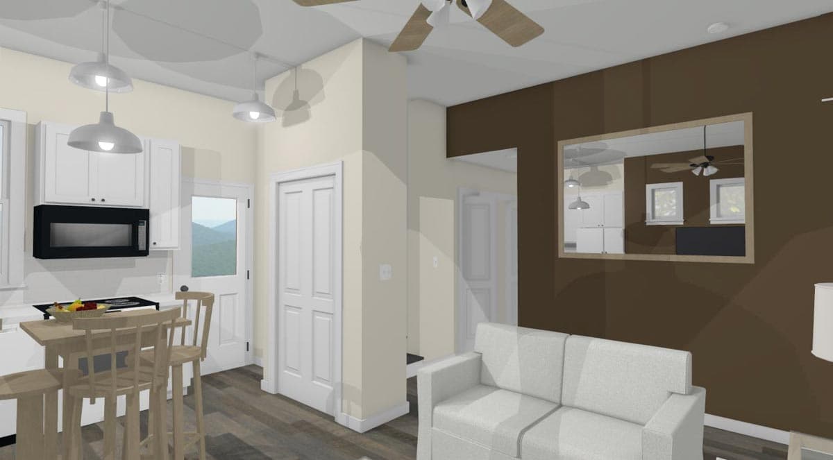 Interior view of a kitchen and living area, featuring white cabinets, island seating, white sofa, and a large mirror reflecting the kitchen.
