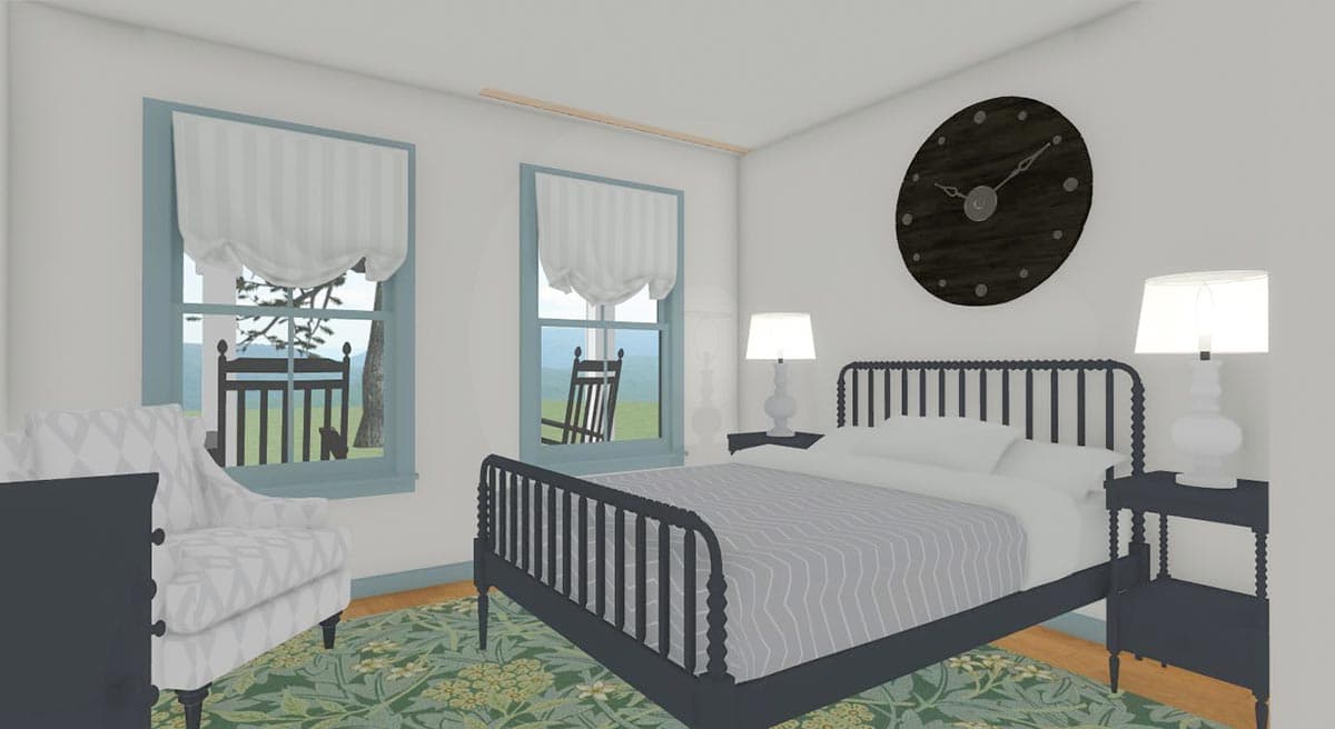 Bedroom with a dark metal bed, patterned armchair, bedside tables with lamps, and two windows overlooking a yard with rocking chairs.